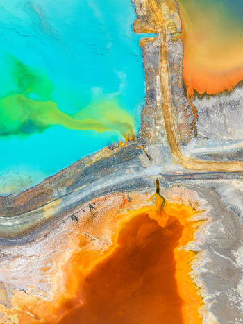 Aerial view of a mining site with vibrant turquoise and orange water pools separated by an industrial road in Andalusia Spain. Aerial view of a mining site with vibrant turquoise and orange water pools separated by an industrial road in Andalusia Spain.