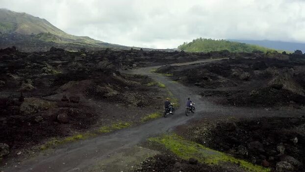 Aerial view of motorcyclists riding through Batur volcano fields Indonesia.