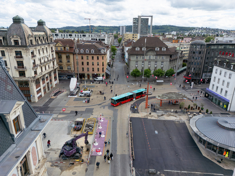 Aerial view of a city square featuring historic architecture an articulated bus and road construction under a cloudy sky in Biel Bienne Canton of Bern Switzerland. Aerial view of a city square featuring historic architecture an articulated bus and road construction under a cloudy sky in Biel Bienne Canton of Bern Switzerland.