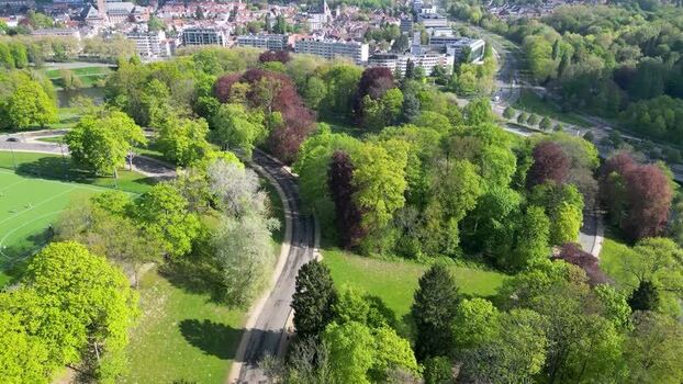 Aerial view of lush green park with winding roads and urban buildings Belgium. Aerial view of lush green park with winding roads and urban buildings Belgium.