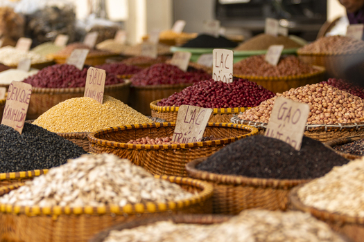 View of various types of grains beans and legumes displayed in woven baskets with handwritten price tags at a local market in Hanoi Ha Noi Vietnam.