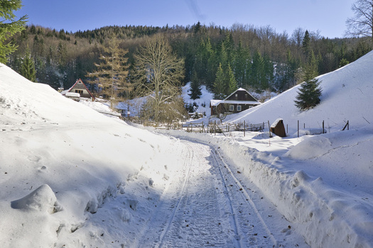 View of winter s embrace blankets the landscape with snow laden paths leading to quaint wooden houses nestled among the trees Moce Banska Bystrica Region Slovakia.