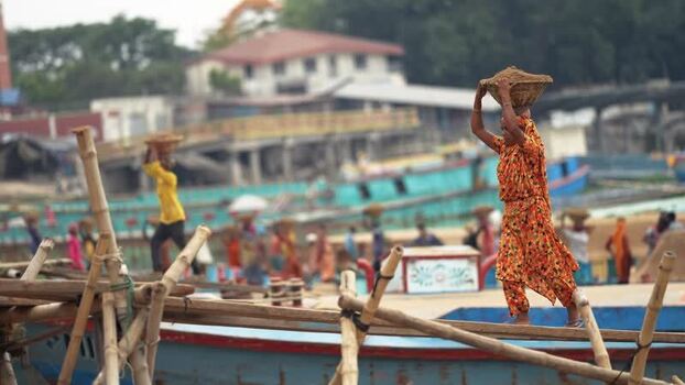 View of workers carrying baskets at Aminbazar river port Bangladesh. View of workers carrying baskets at Aminbazar river port Bangladesh.