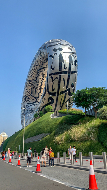 View of The Museum of the Future with its iconic torus shaped structure and Arabic calligraphy set against a clear sky with green landscaping in Dubai Dubai United Arab Emirates. View of The Museum of the Future with its iconic torus shaped structure and Arabic calligraphy set against a clear sky with green landscaping in Dubai Dubai United Arab Emirates.
