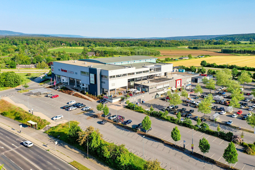 Bamberg Germany 02 May 2026 Aerial view of Brose Arena with its large parking lot and surrounding green landscape under a clear blue sky.