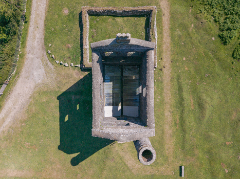 Aerial view of the historic stone mine engine house ruin surrounded by green grass and dirt paths in Minions Cornwall United Kingdom. Aerial view of the historic stone mine engine house ruin surrounded by green grass and dirt paths in Minions Cornwall United Kingdom.