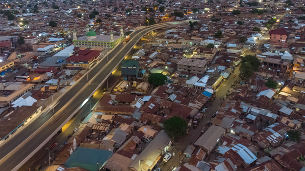 Aerial view of the Tamale Interchange winding through the urban landscape featuring residential rooftops a mosque with a green dome and city streets Tamale Northern Region Ghana.