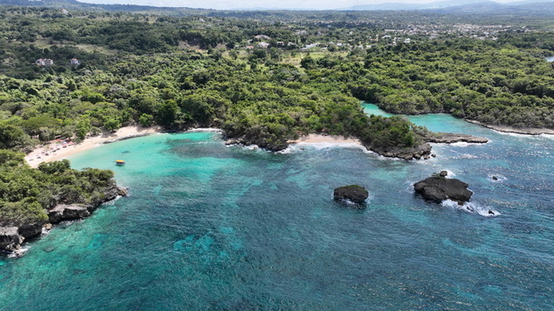 Aerial view of La Casita de Playa with turquoise waters rocky outcrops and lush tropical vegetation along the coastline in Rio San Juan Maria Trinidad Sanchez Dominican Republic.