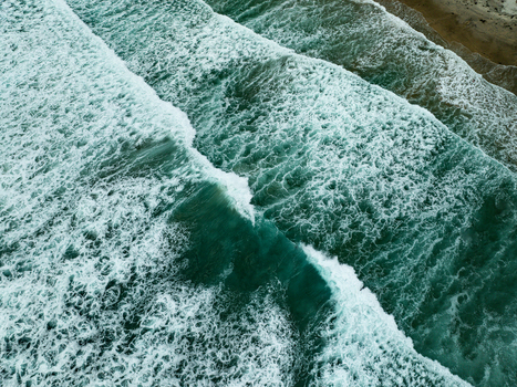 Aerial view of turquoise waves breaking with white foam at La Jolla Cove along the sandy coastline of San Diego California United States. Aerial view of turquoise waves breaking with white foam at La Jolla Cove along the sandy coastline of San Diego California United States.