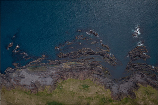Aerial view of Djupalonssandur beach featuring dark volcanic rock formations rugged coastline and deep blue Atlantic ocean waters in Iceland. Aerial view of Djupalonssandur beach featuring dark volcanic rock formations rugged coastline and deep blue Atlantic ocean waters in Iceland.