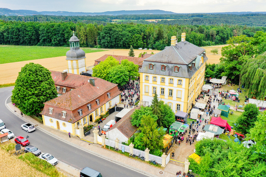Eggolsheim Germany 09 May 2026 Aerial view of Schloss Jagersburg with a crowd of people at an outdoor event surrounded by lush green trees and agricultural fields. Eggolsheim Germany 09 May 2026 Aerial view of Schloss Jagersburg with a crowd of people at an outdoor event surrounded by lush green trees and agricultural fields.