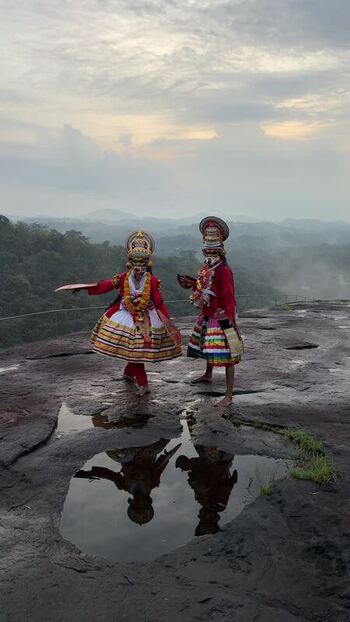 View of traditional Theyyam dancers performing on a rocky hill India. View of traditional Theyyam dancers performing on a rocky hill India.