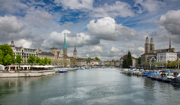 View of the Limmat river in Zurich with historic buildings church spires and boats moored along the banks in Zurich Zurich Switzerland.