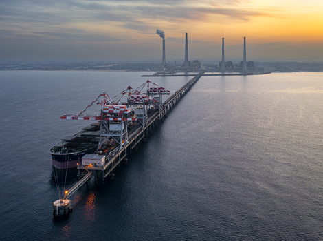 Aerial view of Orot Rabin Power Plant with a large cargo ship docked at the pier during golden hour in Hadera Haifa District Israel. Aerial view of Orot Rabin Power Plant with a large cargo ship docked at the pier during golden hour in Hadera Haifa District Israel.