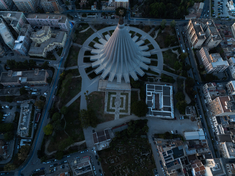 Aerial view of the modern conical architecture of the Basilica of Our Lady of Tears surrounded by green parkland and urban buildings in Syracuse Sicily Italy. Aerial view of the modern conical architecture of the Basilica of Our Lady of Tears surrounded by green parkland and urban buildings in Syracuse Sicily Italy.