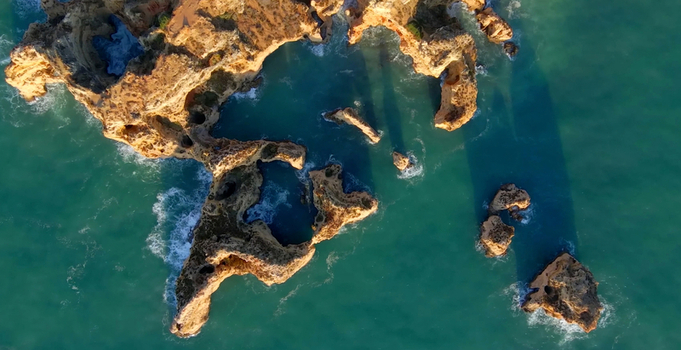 Aerial view of Ponta da Piedade featuring dramatic limestone cliffs sea arches and turquoise waters along the coastline in Lagos Faro Portugal. Aerial view of Ponta da Piedade featuring dramatic limestone cliffs sea arches and turquoise waters along the coastline in Lagos Faro Portugal.