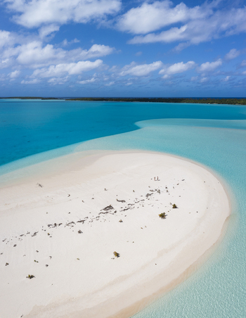 Aerial view of Aitutaki One Foot Island featuring a pristine white sandbank surrounded by turquoise lagoon waters under a bright blue sky Arutanga Cook Islands. Aerial view of Aitutaki One Foot Island featuring a pristine white sandbank surrounded by turquoise lagoon waters under a bright blue sky Arutanga Cook Islands.