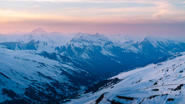 Aerial view of snow capped peaks under a pastel sky Val Thorens Auvergne Rh&ocirc;ne Alpes France.