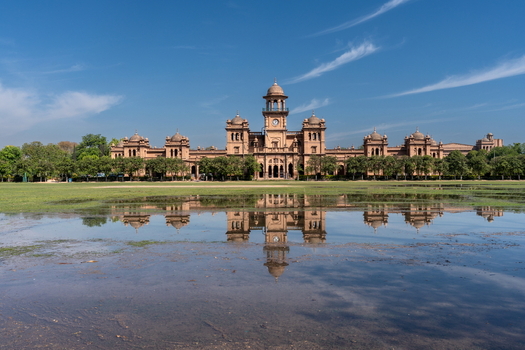View of Islamia College University Peshawar with its historic architecture reflected in the water on the foreground lawn in Peshawar Khyber Pakhtunkhwa Pakistan. View of Islamia College University Peshawar with its historic architecture reflected in the water on the foreground lawn in Peshawar Khyber Pakhtunkhwa Pakistan.