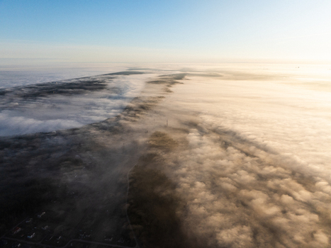 Aerial view of the fog covered landscape around Lake Babite near Sipolciems and Varkali with dense forests and soft morning light in Marupes novads Latvia. Aerial view of the fog covered landscape around Lake Babite near Sipolciems and Varkali with dense forests and soft morning light in Marupes novads Latvia.