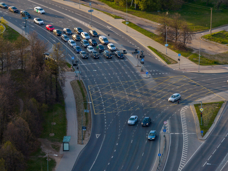 Aerial view of a busy road intersection with cars waiting at traffic lights and yellow box junction markings in Vilnius County Lithuania. Aerial view of a busy road intersection with cars waiting at traffic lights and yellow box junction markings in Vilnius County Lithuania.