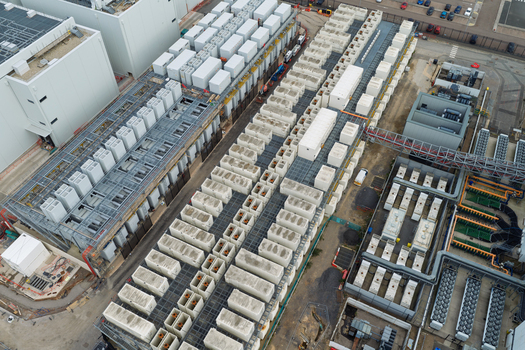 Aerial view of a large data center facility featuring rows of industrial cooling units and HVAC infrastructure on the roof United Kingdom.