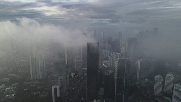 Aerial view of skyscrapers shrouded in thick fog Indonesia. Aerial view of skyscrapers shrouded in thick fog Indonesia.