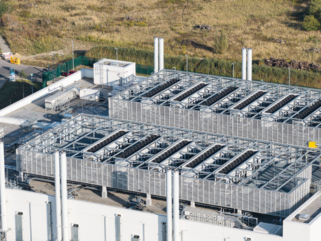 Aerial view of Vantage Data Centers BER1 facility featuring industrial cooling units and ventilation systems on the rooftop in Ludwigsfelde Brandenburg Germany. Aerial view of Vantage Data Centers BER1 facility featuring industrial cooling units and ventilation systems on the rooftop in Ludwigsfelde Brandenburg Germany.