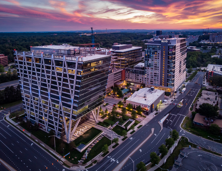 Reston Virginia United States 27 May 2020 Aerial view of modern office buildings and residential towers with geometric facades landscaped plazas and surrounding roads at sunset. Reston Virginia United States 27 May 2020 Aerial view of modern office buildings and residential towers with geometric facades landscaped plazas and surrounding roads at sunset.