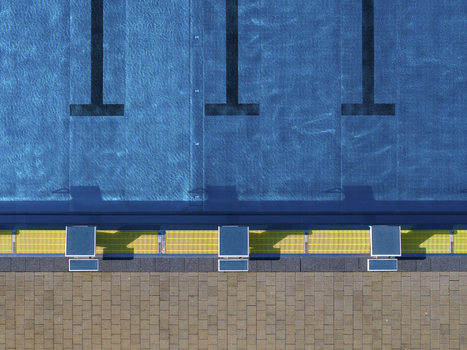 Aerial view of public swimming pools with blue water and diving boards Gropiusstadt Berlin Germany.