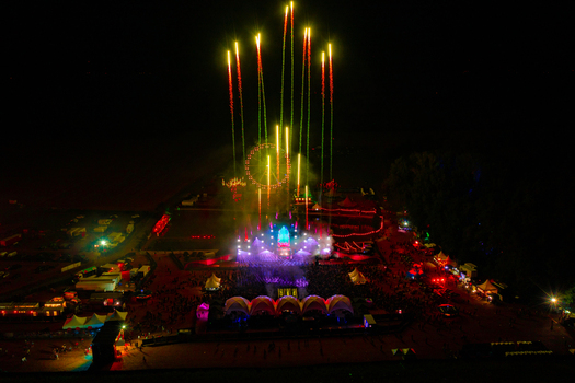 Herzogenaurach Germany 22 July 2022 Aerial view of Open Beatz Festival with fireworks exploding over the main stage a Ferris wheel and crowds of people at night. Herzogenaurach Germany 22 July 2022 Aerial view of Open Beatz Festival with fireworks exploding over the main stage a Ferris wheel and crowds of people at night.