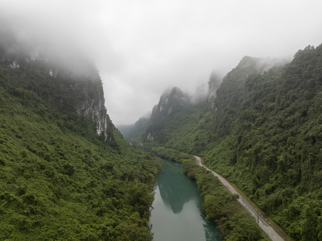 Aerial view of Phong Nha Ke Bang National Park with a winding river and misty karst mountains under a cloudy sky Quang Binh Province Vietnam. Aerial view of Phong Nha Ke Bang National Park with a winding river and misty karst mountains under a cloudy sky Quang Binh Province Vietnam.