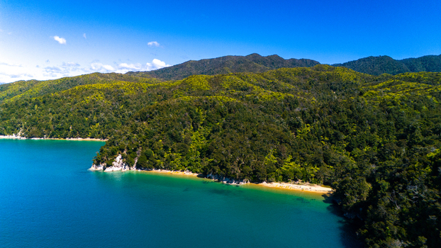 Aerial view of the lush green hills meet the turquoise sea at Abel Tasman National Park a tranquil coastal paradise Abel Tasman National Park Tasman Region New Zealand. Aerial view of the lush green hills meet the turquoise sea at Abel Tasman National Park a tranquil coastal paradise Abel Tasman National Park Tasman Region New Zealand.