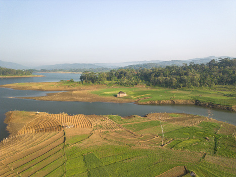 Aerial view of Wadaslintang Reservoir surrounded by lush green agricultural fields terraced farms and dense forests in Wadaslintang Central Java Indonesia. Aerial view of Wadaslintang Reservoir surrounded by lush green agricultural fields terraced farms and dense forests in Wadaslintang Central Java Indonesia.