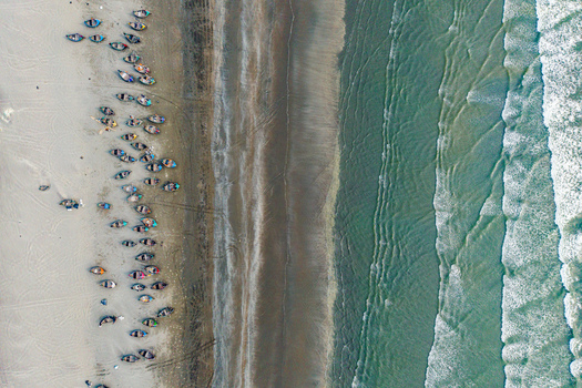 Cox s Bazar Bangladesh 10 March 2026 Aerial view of numerous traditional fishing boats parked on the sandy shore of Cox s Bazar beach with turquoise waves crashing against the coastline. Cox s Bazar Bangladesh 10 March 2026 Aerial view of numerous traditional fishing boats parked on the sandy shore of Cox s Bazar beach with turquoise waves crashing against the coastline.