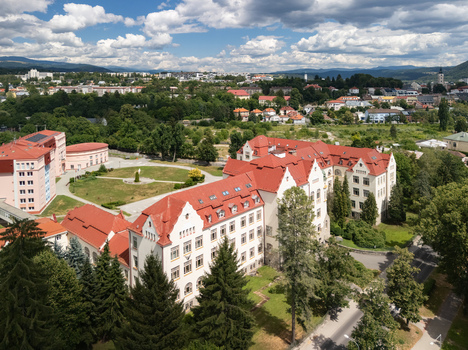 Aerial view of the Faculty of Economics at Matej Bel University with its red tiled roof and historic architecture set amidst green trees in Banska Bystrica Banskobystricky kraj Slovakia. Aerial view of the Faculty of Economics at Matej Bel University with its red tiled roof and historic architecture set amidst green trees in Banska Bystrica Banskobystricky kraj Slovakia.