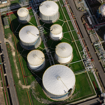 Aerial view of industrial storage tanks and complex piping infrastructure in the industrial zone of Bajos de Haina San Cristobal Province Dominican Republic.