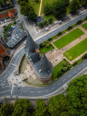 Aerial view of a majestic building with dark conical roofs embraced by curving roads and verdant trees L&uuml;beck Schleswig Holstein Germany.