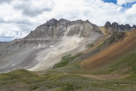 Aerial view of Mount Sneffels in the San Juan Mountains featuring rocky slopes alpine terrain and green meadows in Yankee Boy Basin Ouray County Colorado United States. Aerial view of Mount Sneffels in the San Juan Mountains featuring rocky slopes alpine terrain and green meadows in Yankee Boy Basin Ouray County Colorado United States.