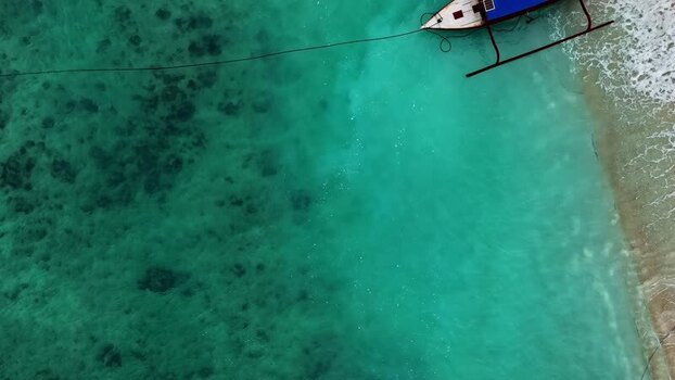 Aerial view of traditional boat in turquoise water Indonesia.