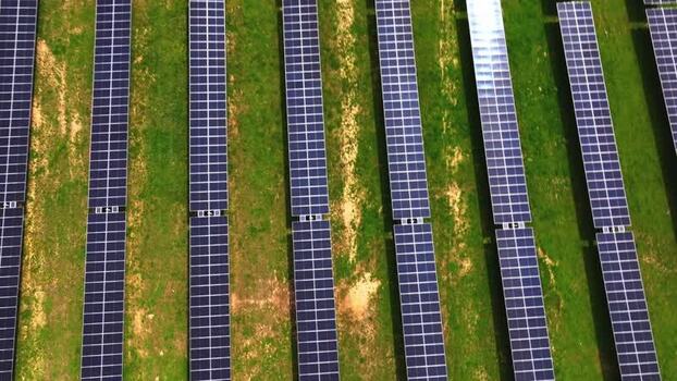 Aerial view of solar panels on green grass United States.