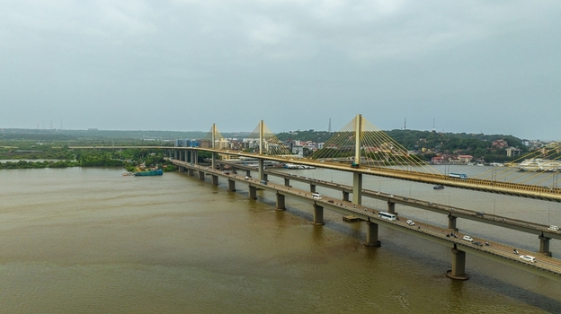 Aerial view of the Atal Setu cable stayed bridge spanning the Mandovi River with traffic flowing across the structure under a cloudy sky in Panaji Goa India.