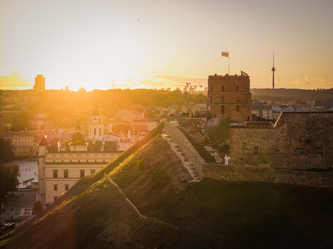 Aerial view of the Gediminas Tower atop the hill bathing in the warm glow of the setting sun contrasting with the city s silhouette Vilnius Lithuania. Aerial view of the Gediminas Tower atop the hill bathing in the warm glow of the setting sun contrasting with the city s silhouette Vilnius Lithuania.