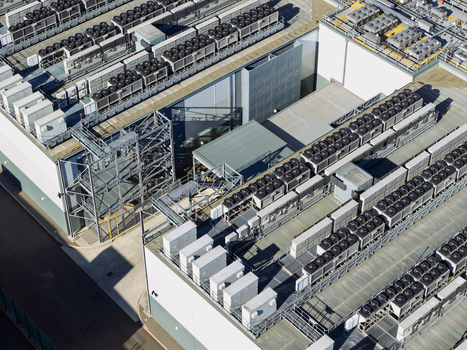 Aerial view of a data center roof featuring rows of industrial HVAC cooling units and ventilation systems in the United Kingdom.