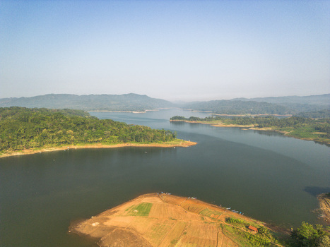 Aerial view of the Wadaslintang Reservoir surrounded by lush green hills and agricultural fields in Wadaslintang Central Java Indonesia. Aerial view of the Wadaslintang Reservoir surrounded by lush green hills and agricultural fields in Wadaslintang Central Java Indonesia.
