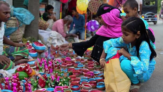 View of children looking at clay toys at a street market Bangladesh. View of children looking at clay toys at a street market Bangladesh.