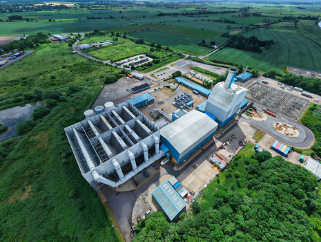 Aerial view of Kings Lynn Power Station with industrial buildings and cooling structures surrounded by green fields and trees in King s Lynn England United Kingdom.