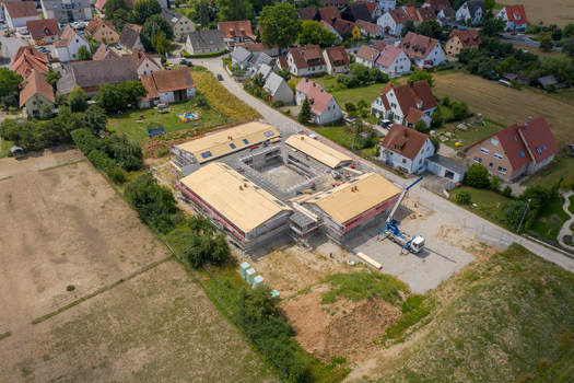 Igensdorf Germany 11 May 2024 Aerial view of a new residential building under construction with a central courtyard surrounded by traditional houses and green gardens. Igensdorf Germany 11 May 2024 Aerial view of a new residential building under construction with a central courtyard surrounded by traditional houses and green gardens.