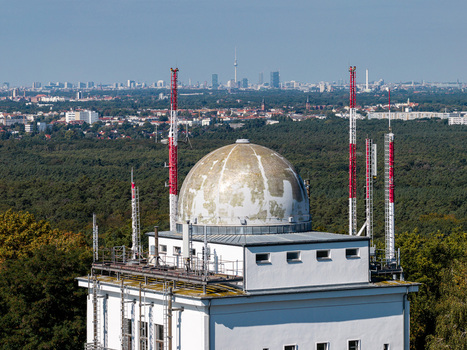 Aerial view of the Muggelturm with its distinctive dome and communication antennas surrounded by the vast forest with the Berlin skyline visible in the distance in Berlin Berlin Germany. Aerial view of the Muggelturm with its distinctive dome and communication antennas surrounded by the vast forest with the Berlin skyline visible in the distance in Berlin Berlin Germany.