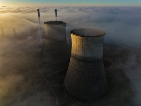 Aerial view of the RWE Clauscentrale cooling towers emerging from a thick layer of morning fog at sunrise in Maasbracht Limburg Netherlands. Aerial view of the RWE Clauscentrale cooling towers emerging from a thick layer of morning fog at sunrise in Maasbracht Limburg Netherlands.